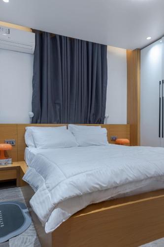 a bedroom with a large bed with white sheets at Aiidraproperties in Lagos