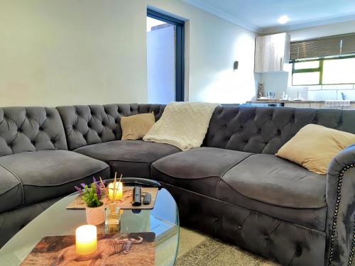 a living room with a leather couch and a glass table at Modern Luxe Escape in Kempton Park