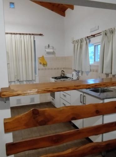 a kitchen with a wooden counter top and a sink at Cabañas Rincon Verde in Merlo