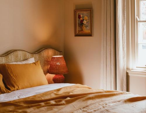 a bedroom with a bed with a lamp and a window at Sona Molong in Molong