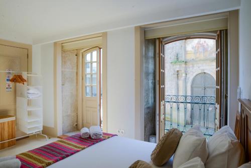a bedroom with a bed and a large window at Casa Matriz Séc XVI in Penafiel