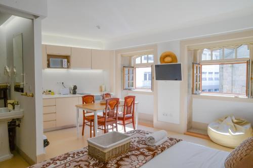 a bedroom with a kitchen and a table and chairs at Casa Matriz Séc XVI in Penafiel