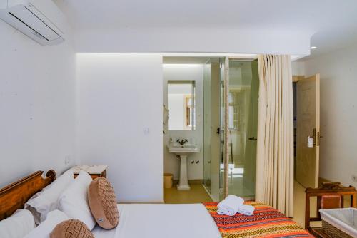 a bedroom with a bed and a bathroom with a shower at Casa Matriz Séc XVI in Penafiel