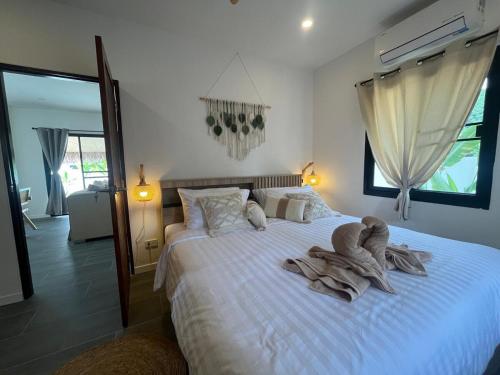 a bedroom with a large bed with towels on it at Villa Sabaï • Private Pool • Thong Krut in Nathon Bay