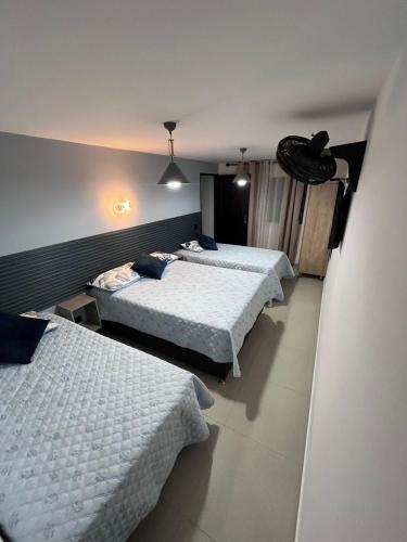 a room with three beds in a room at Hotel Lesus in Medellín