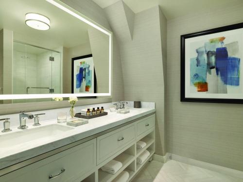 a bathroom with a sink and a large mirror at Fairmont Le Chateau Frontenac in Quebec City