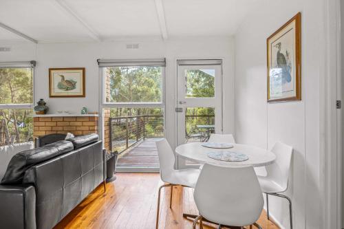 a living room with a table and a couch at Wattletree Cottage Halls Gap in Halls Gap