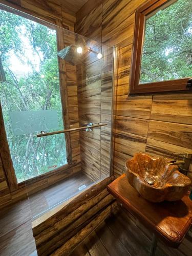 a bathroom with a sink and a glass shower at Cabañas Refugio del Lago in El Cerrillo