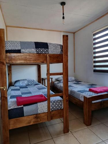 two bunk beds in a room with a window at Cabaña Rústica en Papudo in Papudo