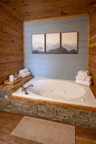 a bath tub in a room with windows at Wilderness Lodge, Hot Tub, Pool Table, Pool Access, WIFIeach paid day in Sevierville