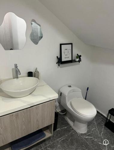 a bathroom with a white toilet and a sink at 10 Caribe, tranquilidad y Casa Familiar in Rodadero