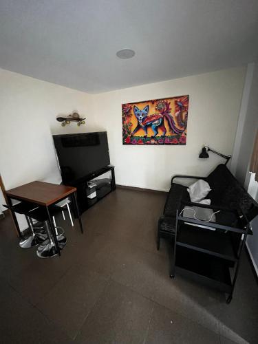 a living room with a couch and a table at Súperanfitrión Coyoacán El Alebrije in Mexico City