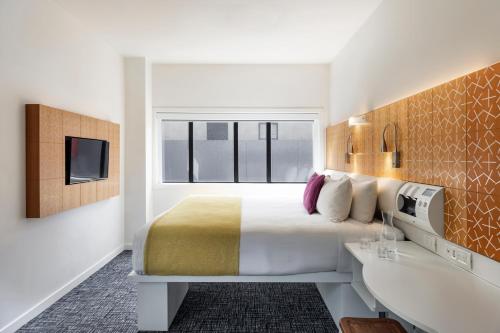 a hotel room with a bed and a tv at BreakFree on Cashel, an Accor Hotel in Christchurch