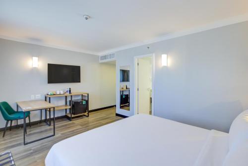 a hotel room with a bed and a desk and a tv at Park Inn by Radisson Berrini in São Paulo
