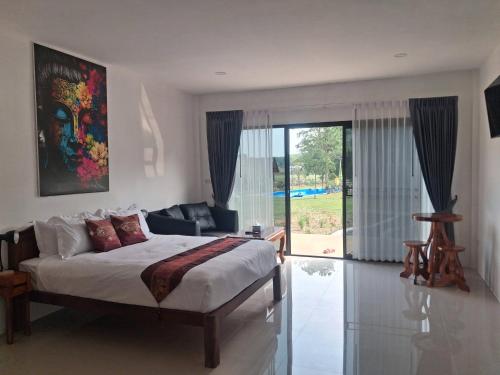 a bedroom with a bed and a sliding glass door at Isaan Country Retreat in Mukdahan
