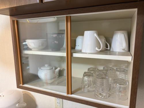 a cabinet filled with dishes and cups and other items at フューデイズコンドミニアム定山渓206号室 in Jozankei