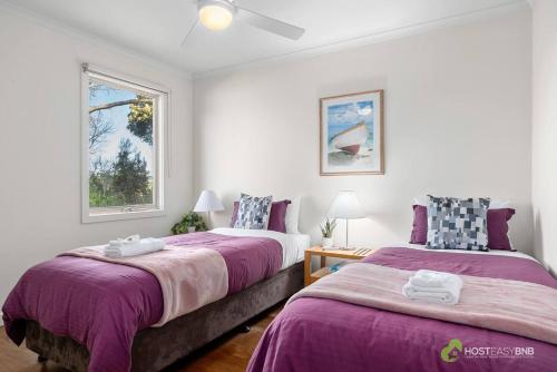 two beds in a room with two windows at Phillip Island Resort Villa 148 Amazing Views in Cowes