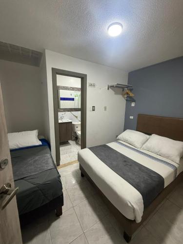 a bedroom with two beds and a door to a bathroom at CASA HOTEL VICTORIA Av 30 in Bogotá