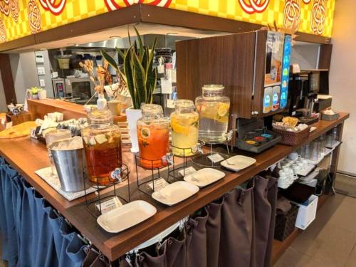 a bar with several glasses of drinks on a counter at Henn na Hotel Kanazawa Korimbo in Kanazawa