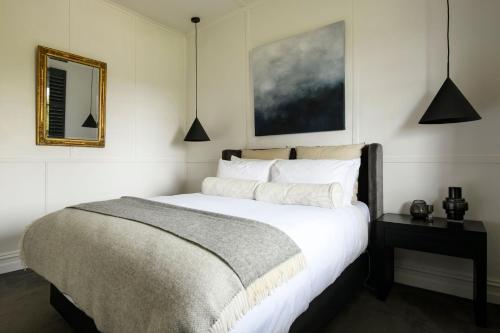 a bedroom with a bed and a mirror on the wall at Little Wombat Daylesford in Daylesford