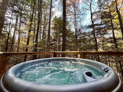 a hot tub in the middle of the woods at The Founder - Iconic Rockhouse Cabin in Campton