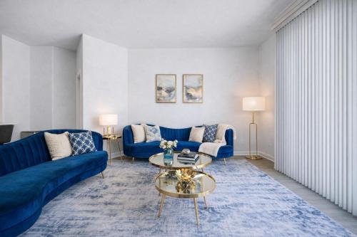 a living room with blue couches and a table at Venice Marina Pool and Spa Luxury Condo in Los Angeles