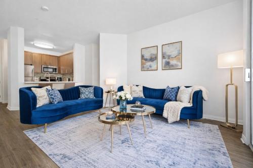 a living room with a blue couch and a table at Venice Marina Pool and Spa Luxury Condo in Los Angeles