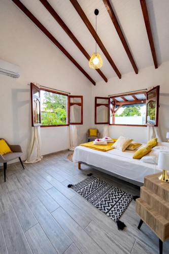 a bedroom with a bed and two windows at Villa Belle Ile en Mer in Capesterre