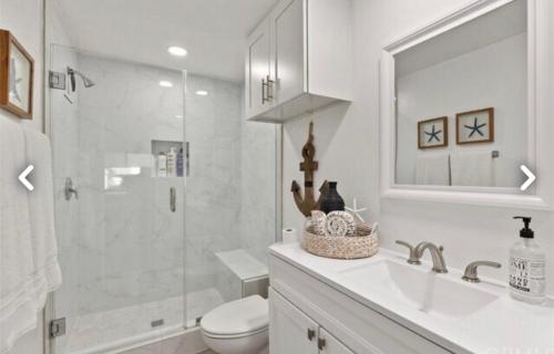 a bathroom with a shower and a toilet and a sink at Beach Condo in Dana Point