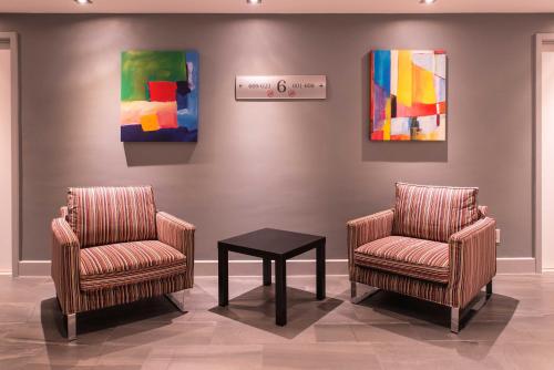 two chairs and a table in a room with a painting at Travelodge by Wyndham Montreal Centre in Montréal