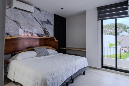 a bedroom with a large bed and a stone wall at Casa Parota in Naranjo