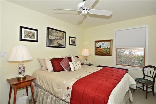 a bedroom with a large bed with a red blanket at Gem-By-The-Sea in Cape May Point