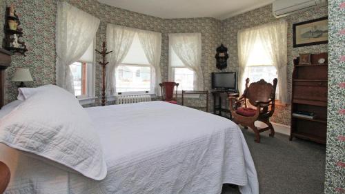 a bedroom with a bed and a tv and windows at Saltwood House in Cape May