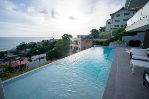 a large swimming pool with a view of the ocean at Avaya Oasis - Villa Trinidad in Carenage