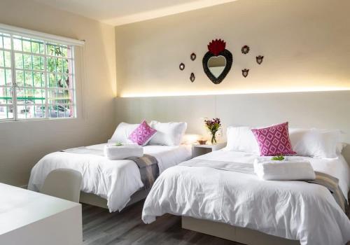 two beds in a room with a mirror on the wall at Dazzling house in the heart of Coyoacan/12 guests in Mexico City