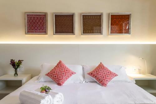 a white bed with red pillows on top of it at Dazzling house in the heart of Coyoacan/12 guests in Mexico City
