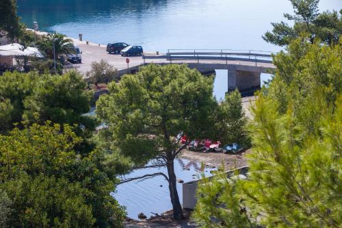 a bridge over a body of water with a tree at Apartments Bruna in Lastovo