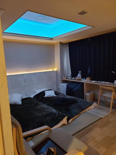 a bedroom with a large bed with a blue light at Business Hotel Takanoya in Hadano