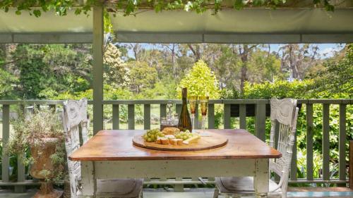 a wooden table with a plate of fruit on it at Saint Eloi Le Studio in Bowral