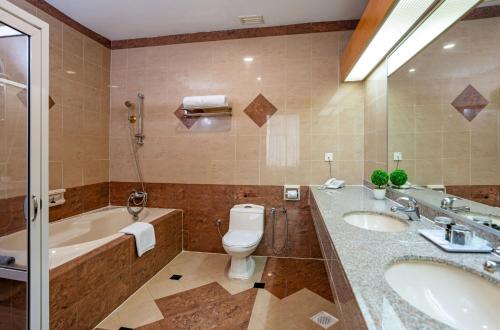a bathroom with a tub and a toilet and a sink at New York Hotel in Johor Bahru