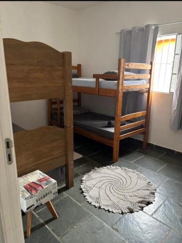 a room with two bunk beds and a rug at Quarto para 4 hóspedes in Itu
