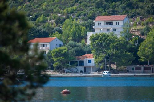 a group of houses on the shore of a lake at Apartments Bruna in Lastovo