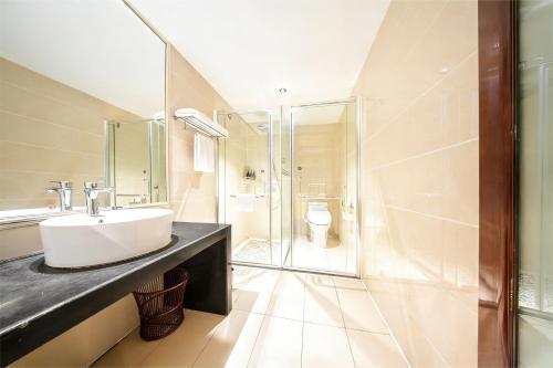 a bathroom with a sink and a shower at 济南璞秀酒店-山东师范大学千佛山店Cultural Experience Hotel in Jinan