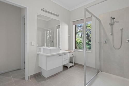 a white bathroom with a sink and a shower at The Buckleys Escape in Point Lonsdale
