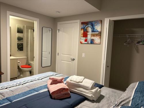 a bedroom with a bed with towels on it at Beyond comfort - arriveYYC in YYC