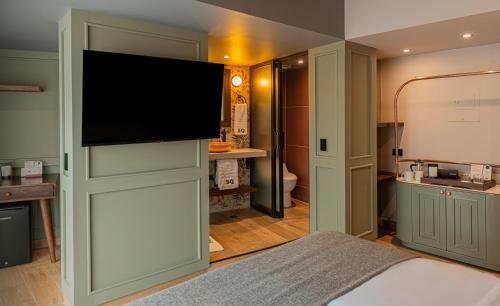 a bedroom with a flat screen tv on a wall at 5Q House Chapinero in Bogotá