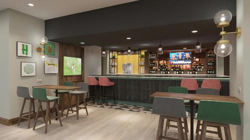 a restaurant with tables and chairs and a bar at Holiday Inn Ashford Central by IHG in Ashford