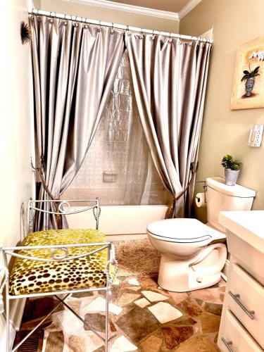 a bathroom with a toilet and a shower curtain at The Tee Time Cottage in Augusta
