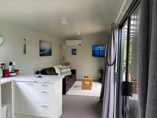 a kitchen and living room with a couch at BB'S Cabin in Kerikeri