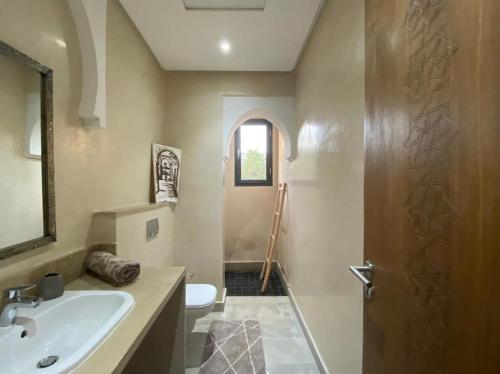 a bathroom with a sink and a toilet and a mirror at Villa nomad marrakech in Douar bel Rhanodour